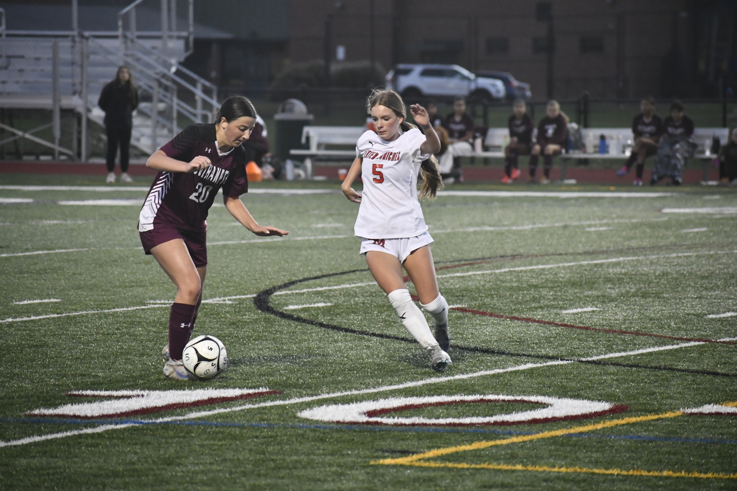 Southampton sophomore Isabella Glorioso plays a ball with Center Moriches senior Kieren Weinstein coming up on her.  DREW BUDD