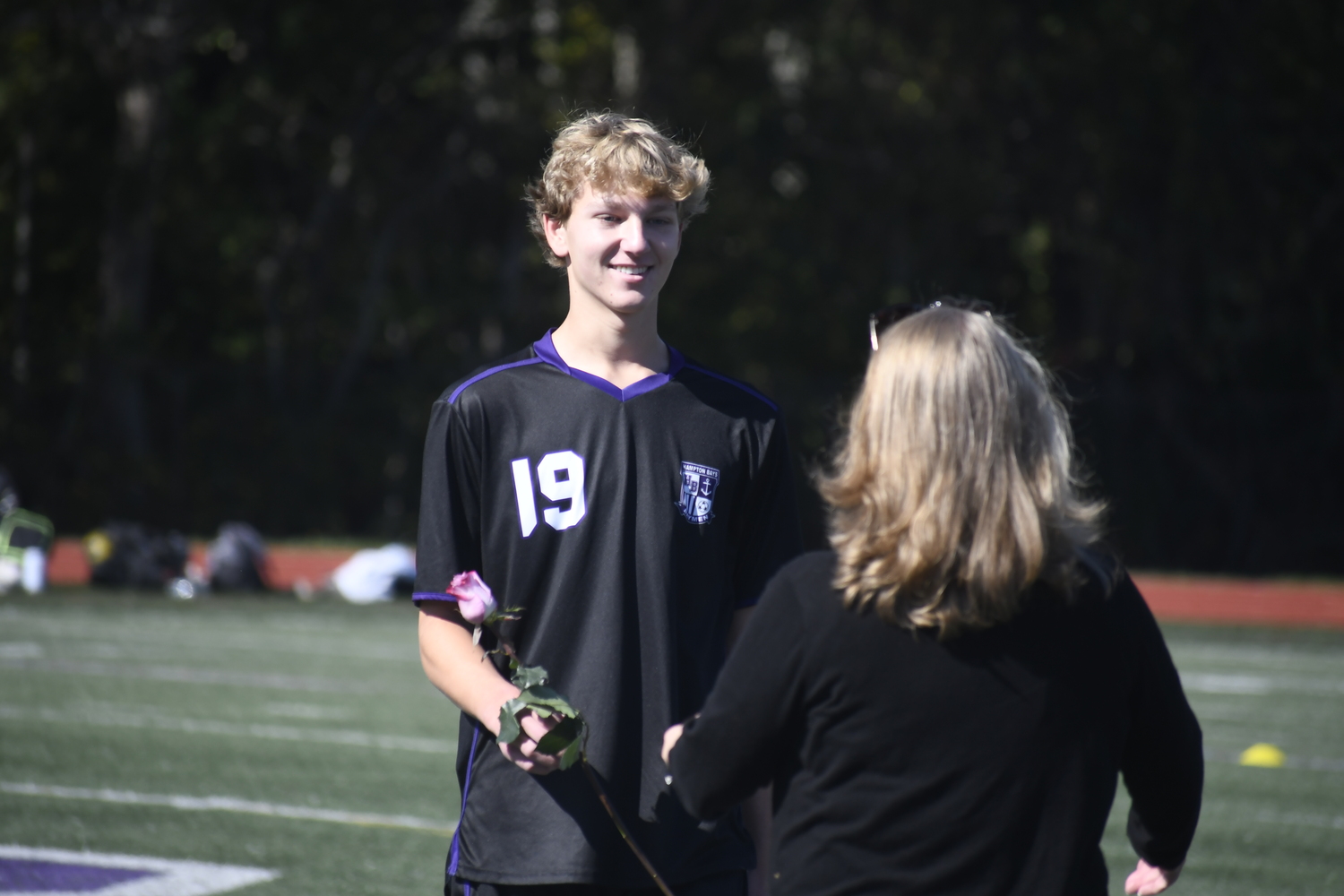 Sean Korczak hands a rose to his mother and family as part of Saturday's pregame ceremony.  DREW BUDD