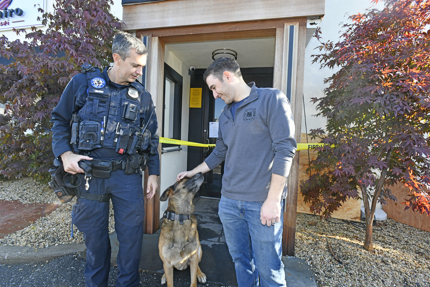 Southampton Village Police Officer James Moore and Southampton fire Department Assistant Chief Kenny Lockard, a village resident who also happens to be a co-owner of Namiro, with Topper in front of the restaurant on Wednesday morning.  DANA SHAW