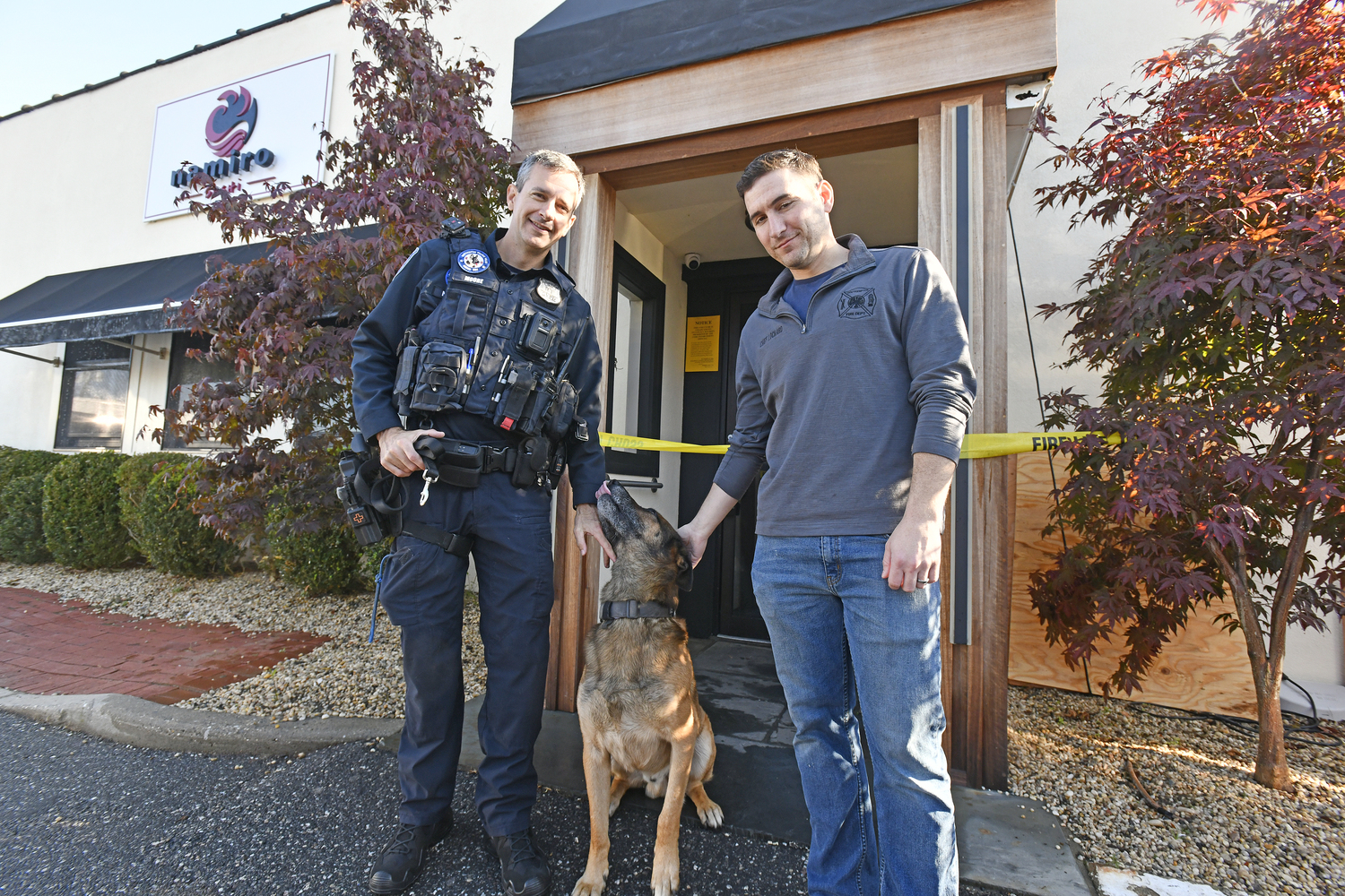 Southampton Village Police Officer James Moore and Southampton fire Department Assistant Chief Kenny Lockard, a village resident who also happens to be a co-owner of Namiro, with Topper in front of the restaurant on Wednesday morning.  DANA SHAW