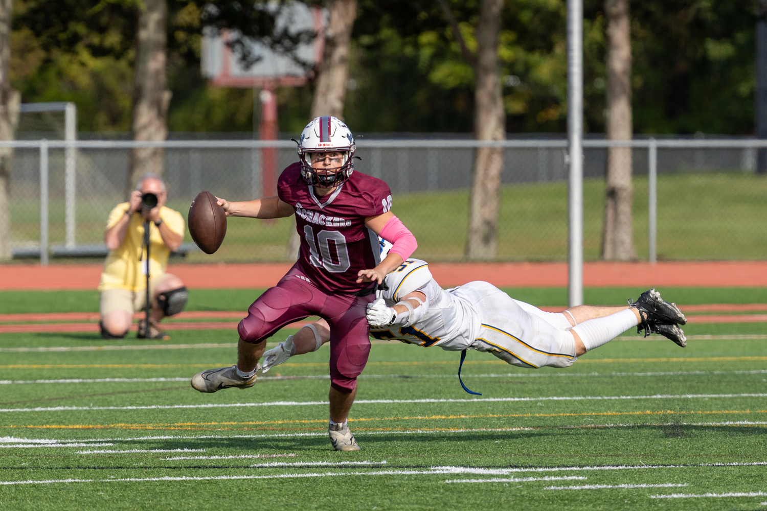 East Hampton senior quarterback Theo Ball eludes a West Islip defender.  RON ESPOSITO