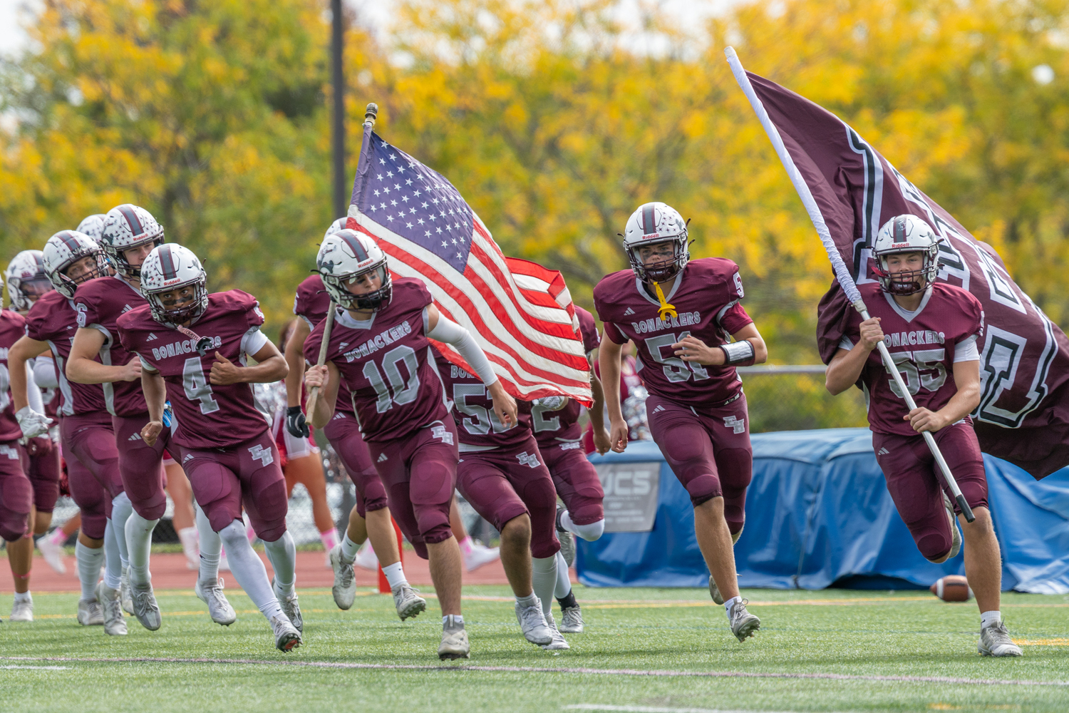 Alex Davis (4), Pax Minardi (10), James Corwin (51) and Tyler Rodgers (55) lead the Bonackers onto their home field on Saturday afternoon.  RON ESPOSITO