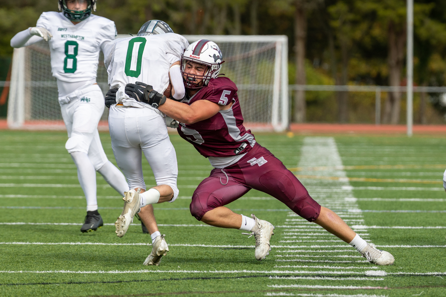 East Hampton junior Jackson Ronick wraps up Westhampton Beach senior Nate LoGelfo.  RON ESPOSITO