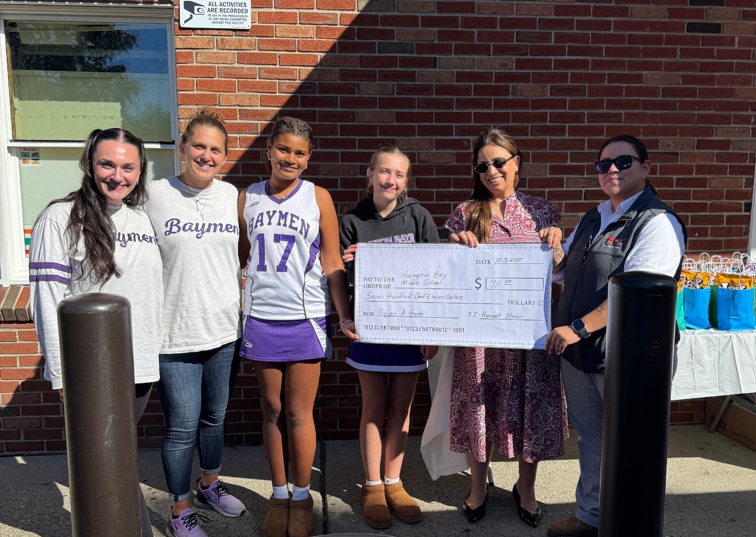 Hampton Bays Middle School recently accepted a check from the 7-Eleven
Cares Foundation for $711. The funds will be used to provide financial aid to students in
need who would like to attend the school’s annual Frost Valley field trip. From left, Brittany Griffin, seventh/eighth grade math teacher and eighth grade class
adviser; Renee Calabrese, social worker and eighth grade class adviser; Maya Ollennu, Class of 2030 treasurer; Hayden Wilson, Class of 2030 president; Rameet Bhasin, 7-Eleven store owner; and Ingrid Solis, 7-Eleven district manager. COURTESY HAMPTON BAYS SCHOOL DISTRICT