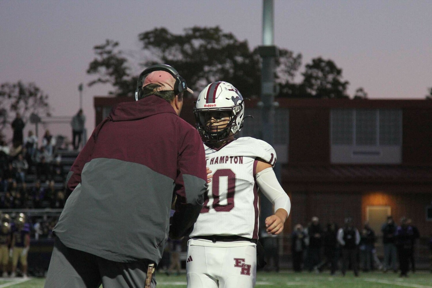 East Hampton head coach Joe McKee gives a play to senior quarterback Theo Ball.  JACEN SHEADES