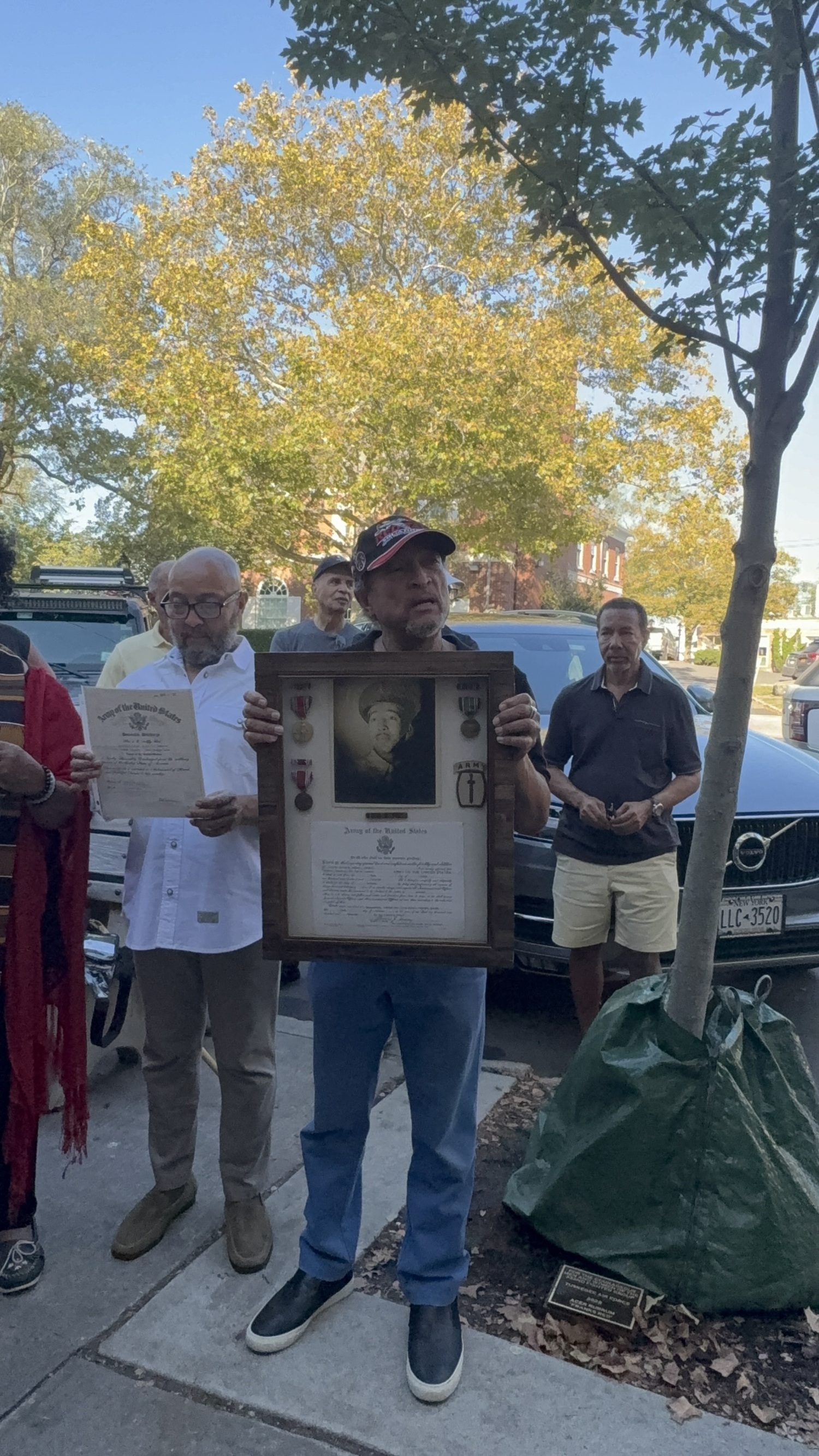 Sag Harbor resident Michael Butler holds a photo of his father, Charles M. Butler, who served as a Tuskegee Airman during World War II. CAILIN RILEY