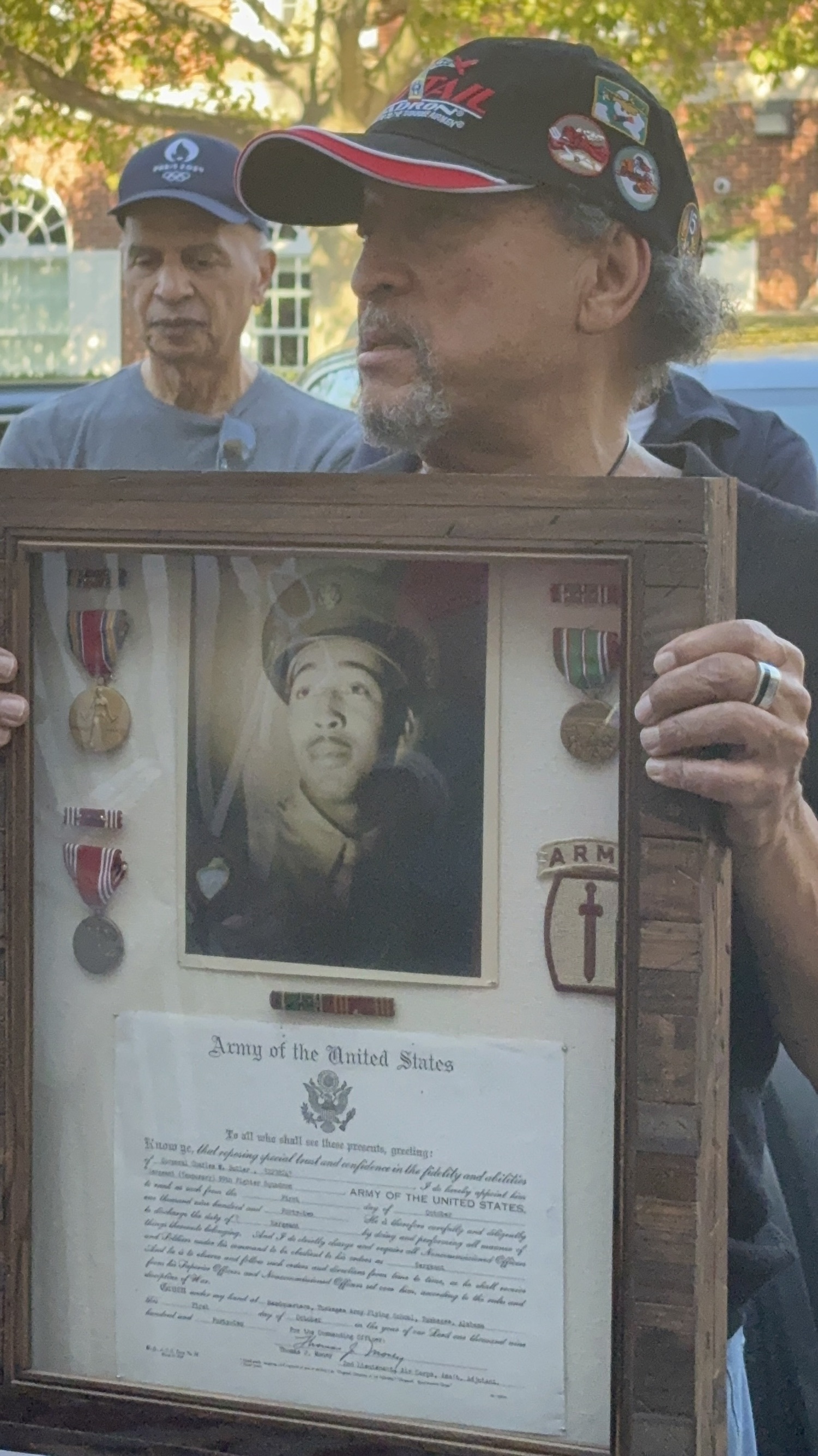 Sag Harbor resident Michael Butler holds a photo of his father, Charles M. Butler, who served as a Tuskegee Airman during World War II. CAILIN RILEY