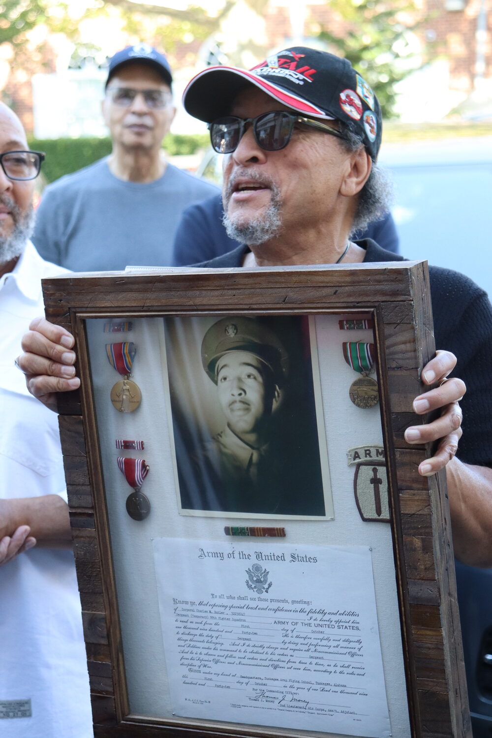 Sag Harbor resident Michael Butler holds a photo of his father, Charles M. Butler, who served as a Tuskegee Airman during World War II. CAILIN RILEY
