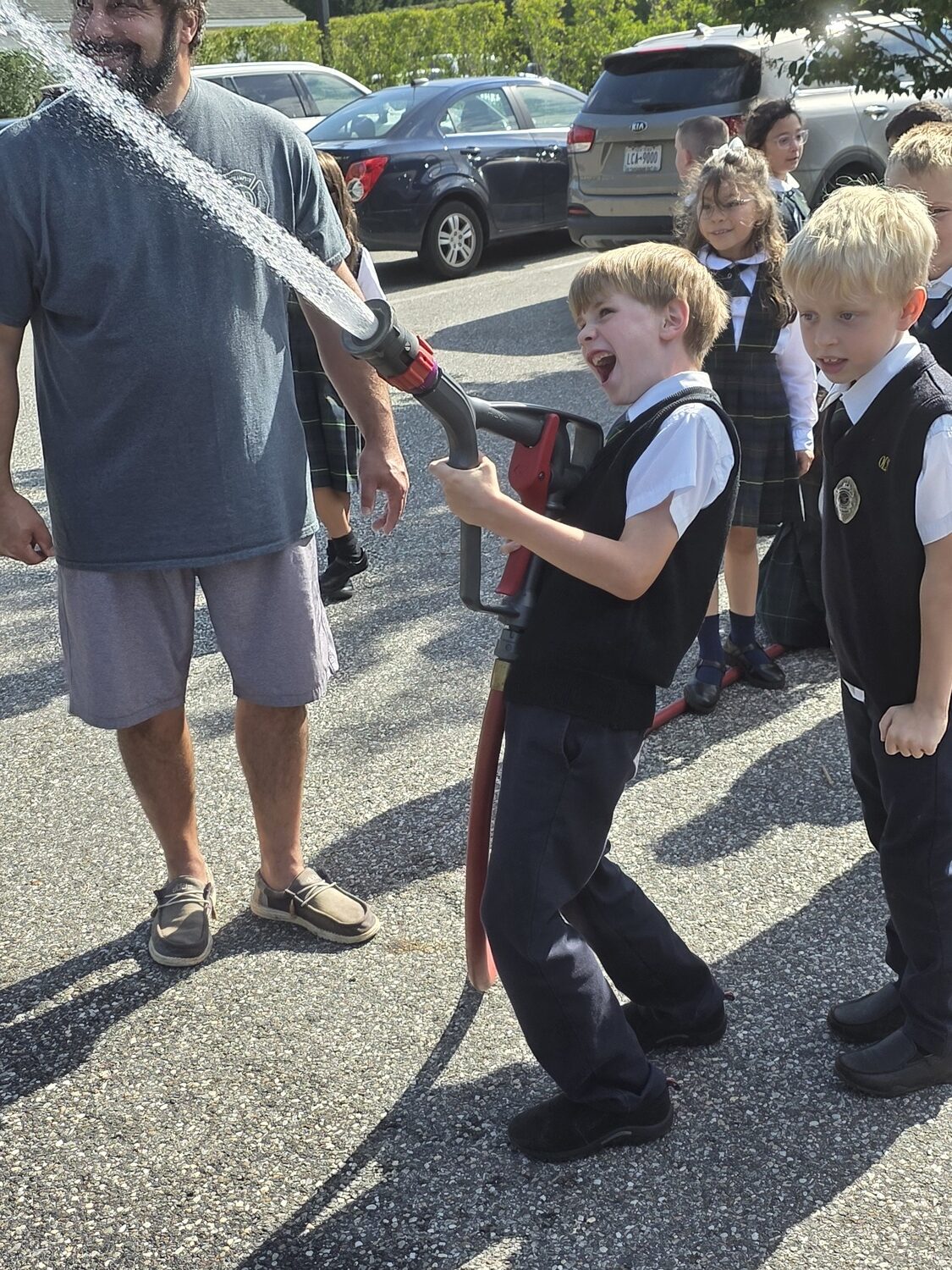 The Southampton Fire Department visited Our Lady of the Hamptons School recently for its annual Fire Safety Day, during which students in kindergarten through fourth grade receive hands-on instruction in fire prevention and safety measures. Third-graders Kevin Springer and John Brock-Foley got a try at the fire hose. COURTESY OUR LADY OF THE HAMPTONS SCHOOL