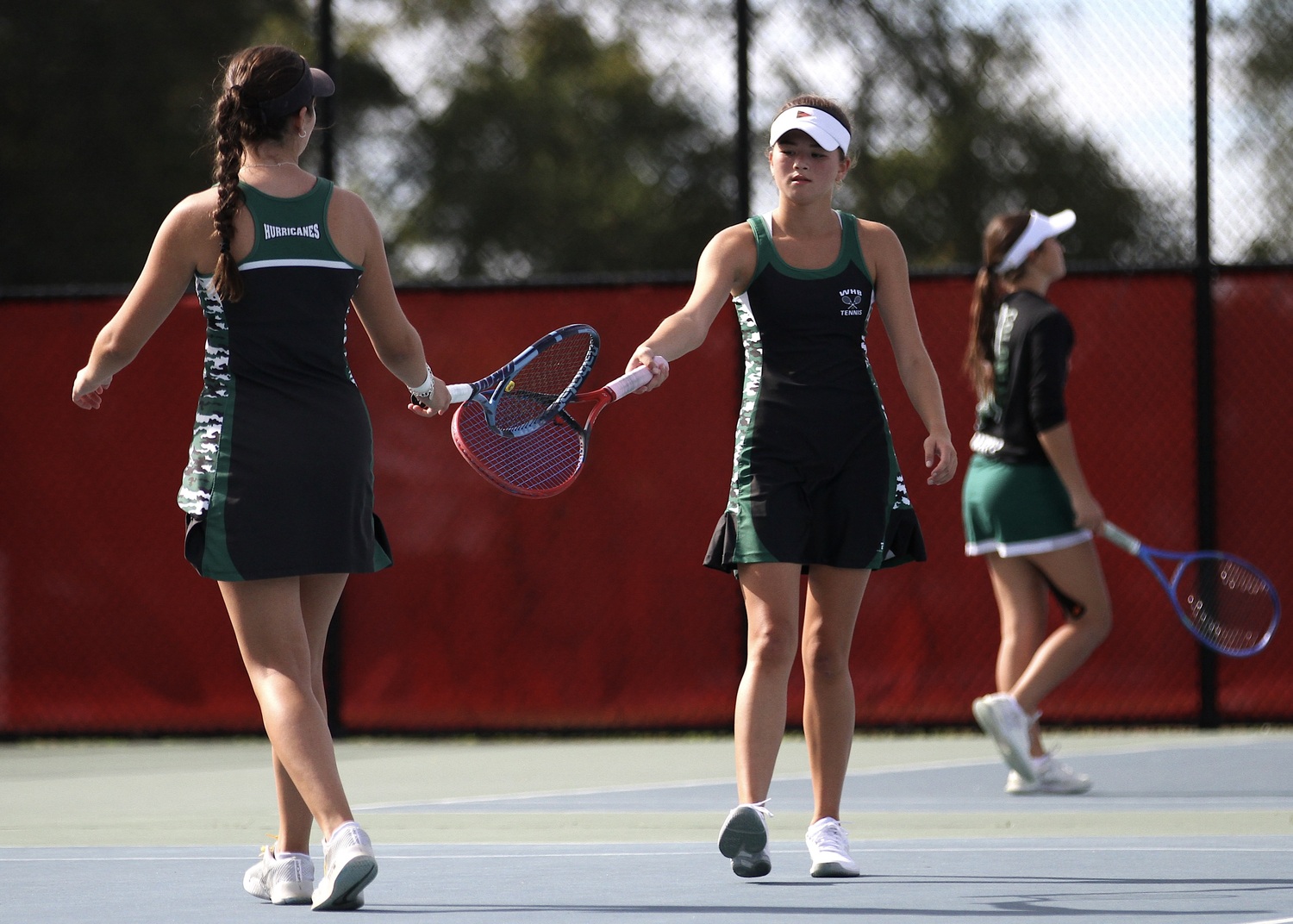 Westhampton Beach seniors Ana Way and Diana Elliott touch rackets after a regroup. DESIRÉE KEEGAN