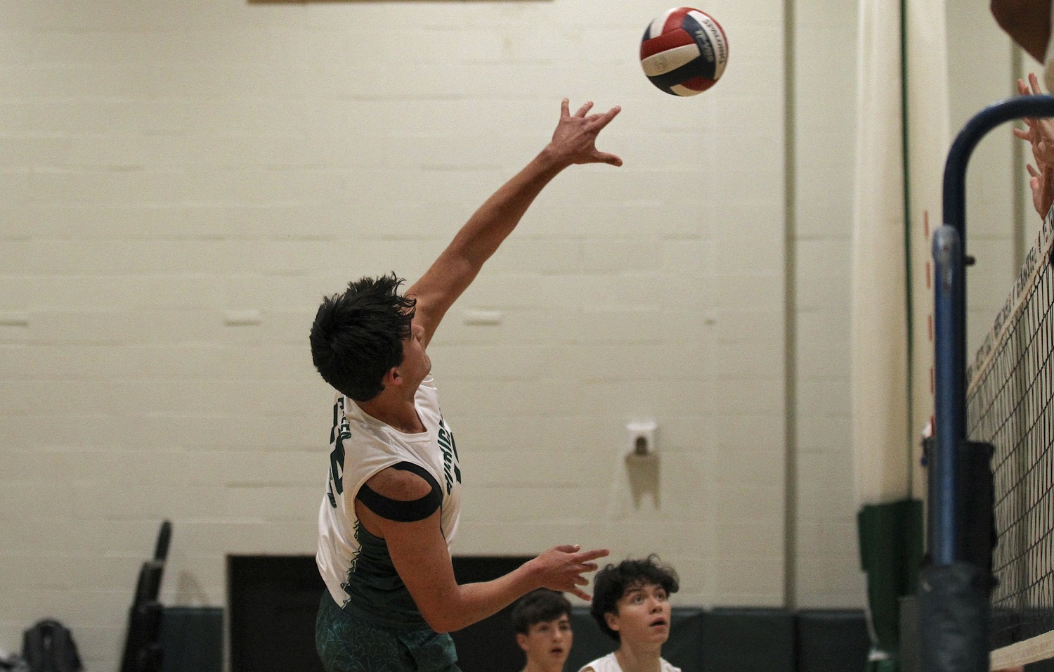 Westhampton Beach senior right side Jude Allen sends the ball back over the net. DESIRÉE KEEGAN