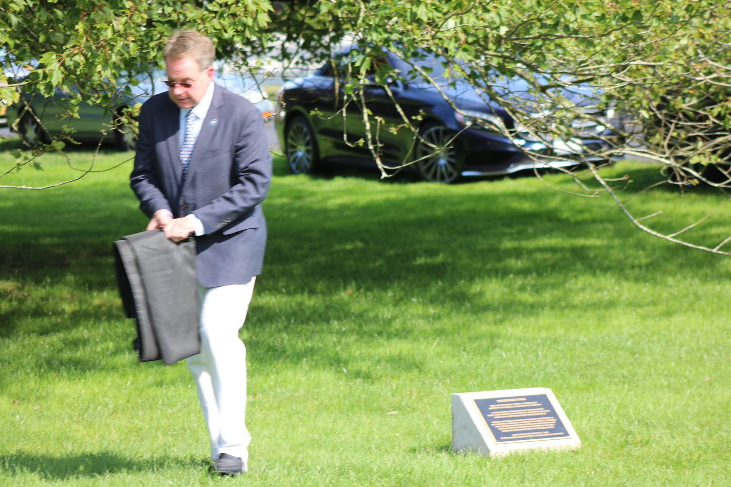 East Hampton Village Mayor Jerry Larsen removes the covering from the plaque. JACK MOTZ