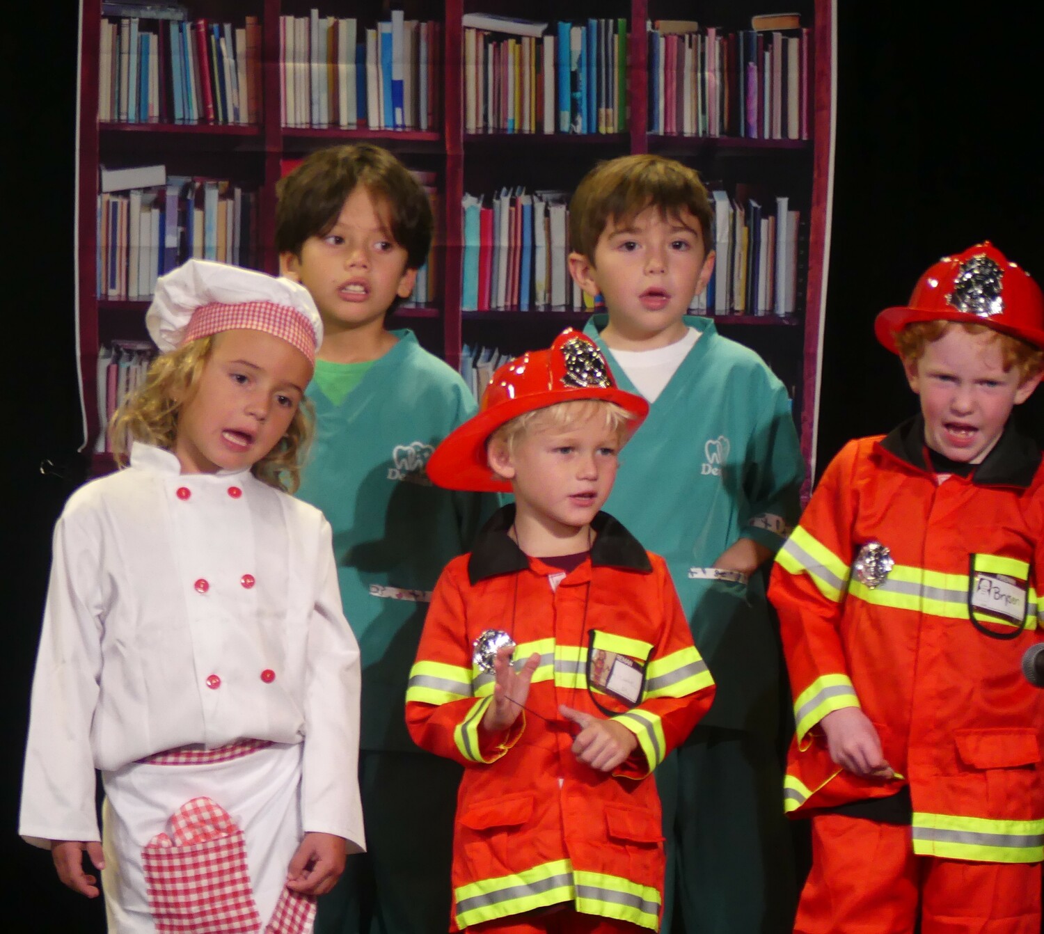 Our Lady of the Hamptons School teacher Claire Zaneski and her first grade students  presented a musical tribute to community helpers as their class assembly, dressed as crossing guards, fire and police personnel, chefs, construction and medical personnel. Front, Piper Callahan, Michael Milani, Brysen Blodorn; back, Santiago Arango and Massimo Jimenez. COURTESY OUR LADY OF THE HAMPTONS SCHOOL