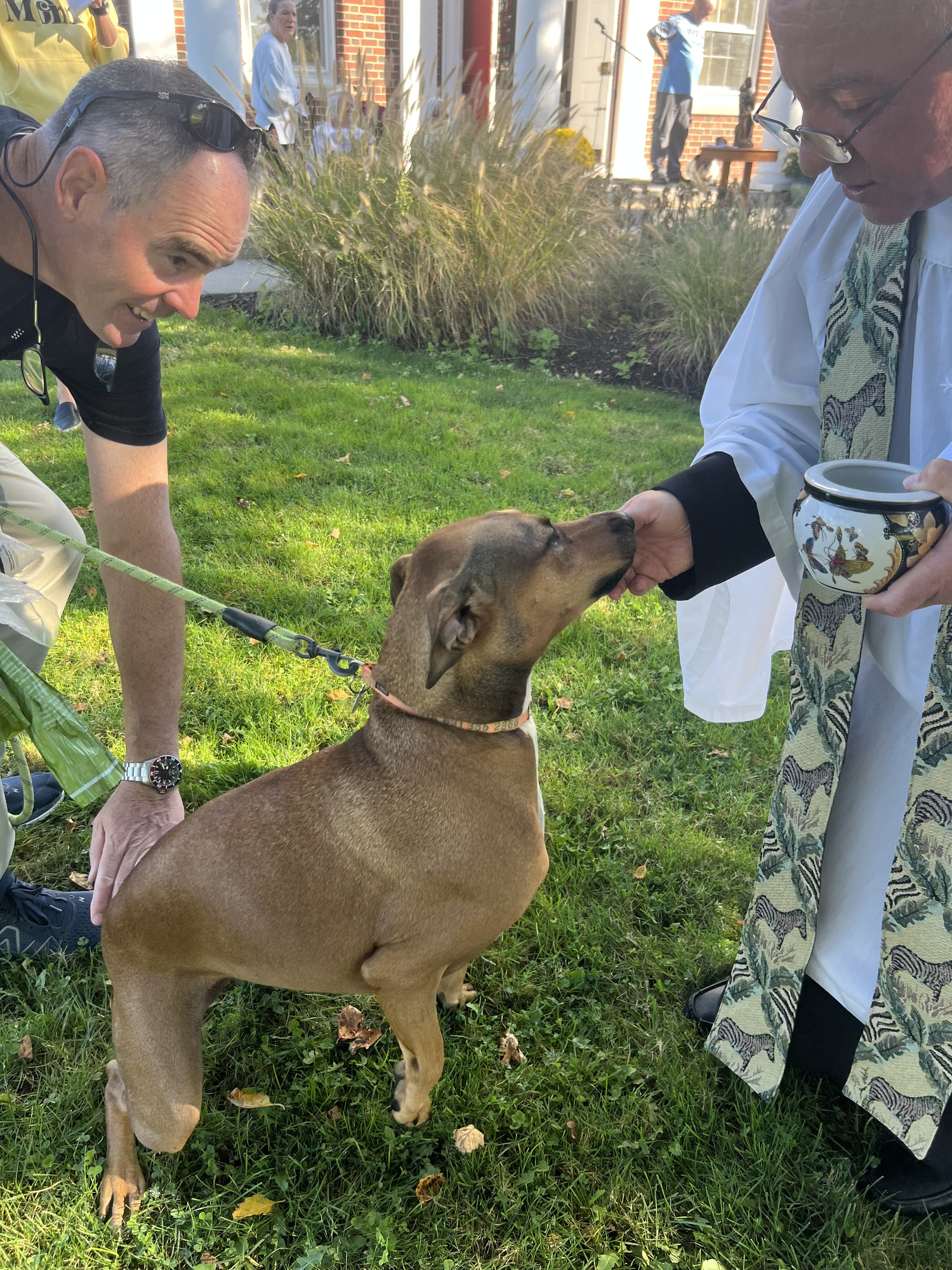 Father Chris Jubinski, pastor at St. Mark's Church in Westhampton Beach, blessed the  animals of those in the community who wished to participate on October 4. In all,  32 people brought their pets, including Larry Luce and his dog Tia. COURTESY TOM HADLOCK