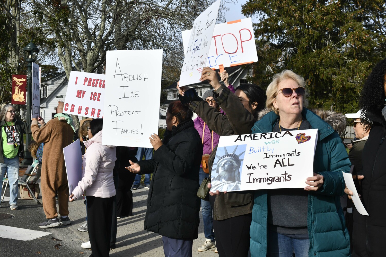 Protesters lined Montauk Highway in Hampton Bays on Friday morning voicing their objections to immigration raids that ensnared several people in the community and in Westhampton and Riverhead earlier in the week. DANA SHAW