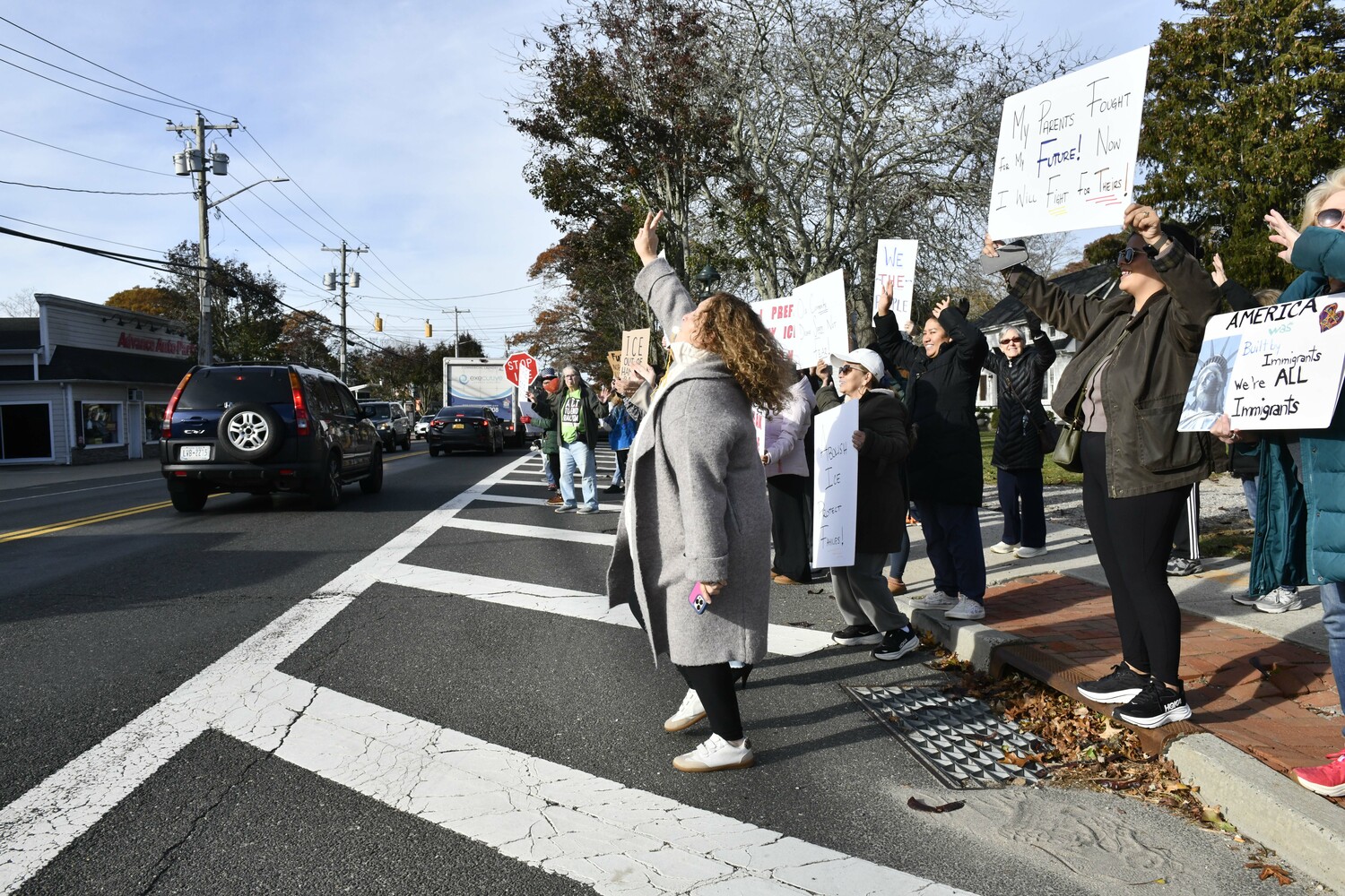 Protesters lined Montauk Highway in Hampton Bays on Friday morning voicing their objections to immigration raids that ensnared several people in the community and in Westhampton and Riverhead earlier in the week. DANA SHAW
