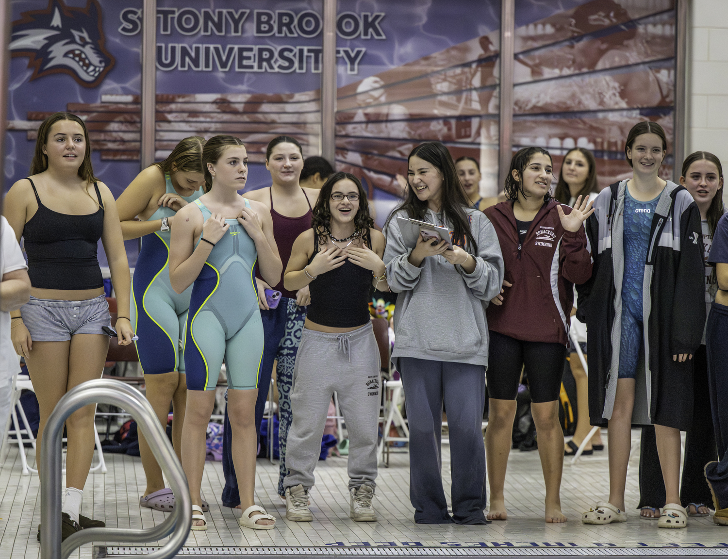 Swimmers cheer on the final relay of the day, the 400-yard freestyle.  MARIANNE BARNETT