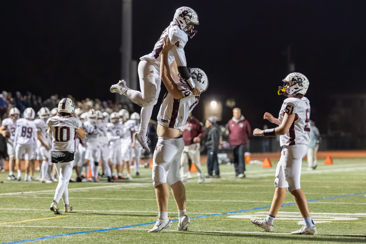 Lineman Sully Matthews hoists up Alex Davis after one of his four touchdowns during Friday night's playoff victory at Islip.  RON ESPOSITO