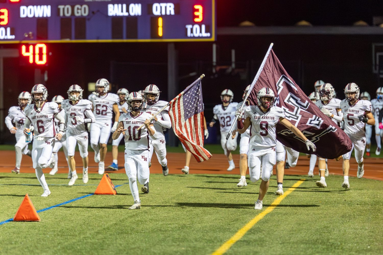 Theo Ball (10) and Charlie Stern (9) lead the Bonackers onto the turf at Islip High School on Friday night.  RON ESPOSITO