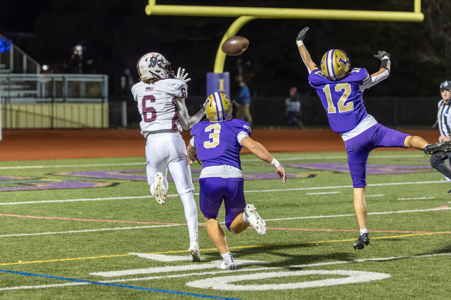 East Hampton senior Livs Kuplins has a pass in his sights thrown over a pair of Islip defenders by senior quarterback Theo Ball.  RON ESPOSITO