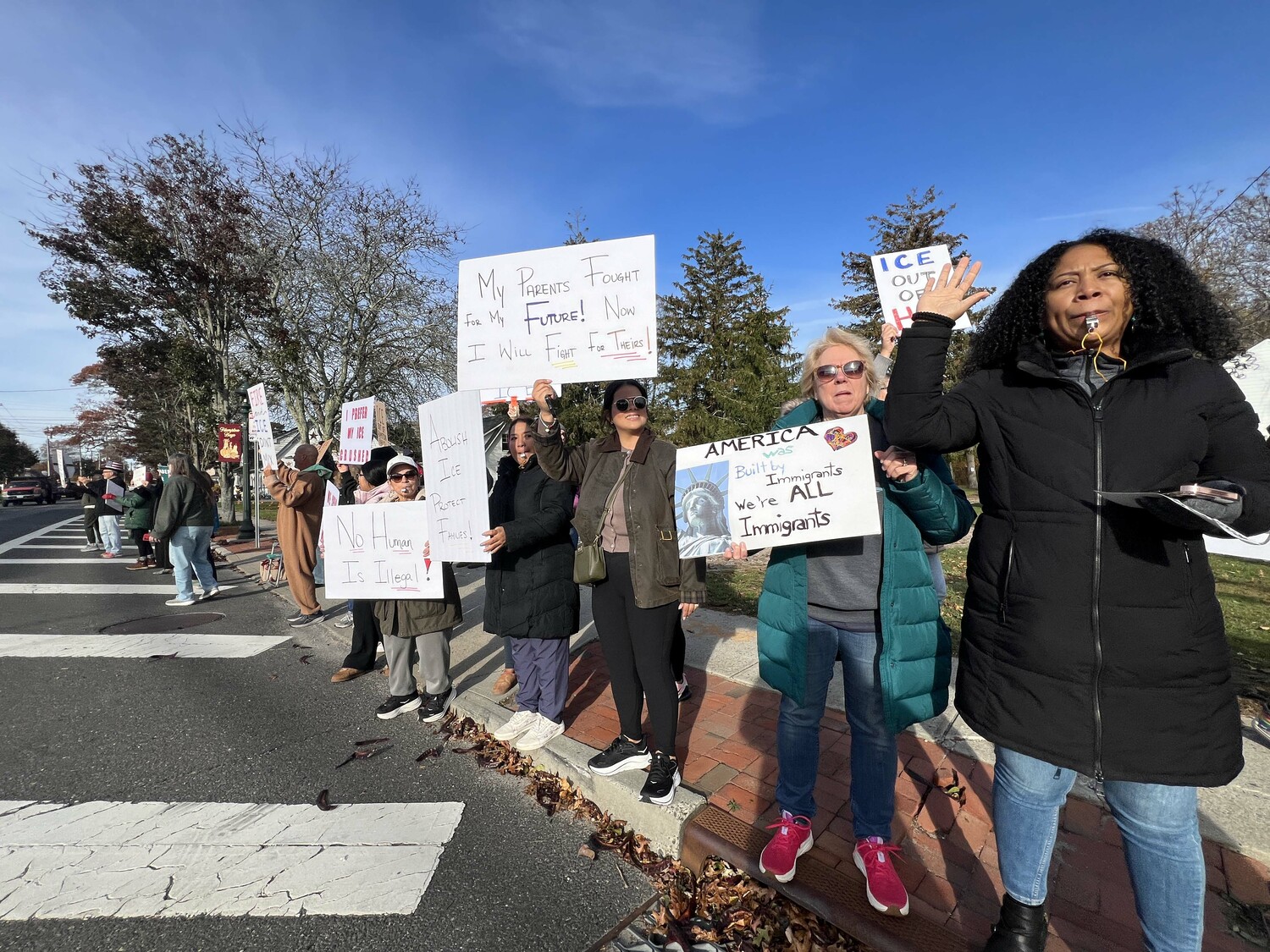 Protesters lined Montauk Highway in Hampton Bays on November 7, voicing their objections to immigration raids that ensnared several people in the community and in Westhampton and Riverhead earlier in the week. DANA SHAW