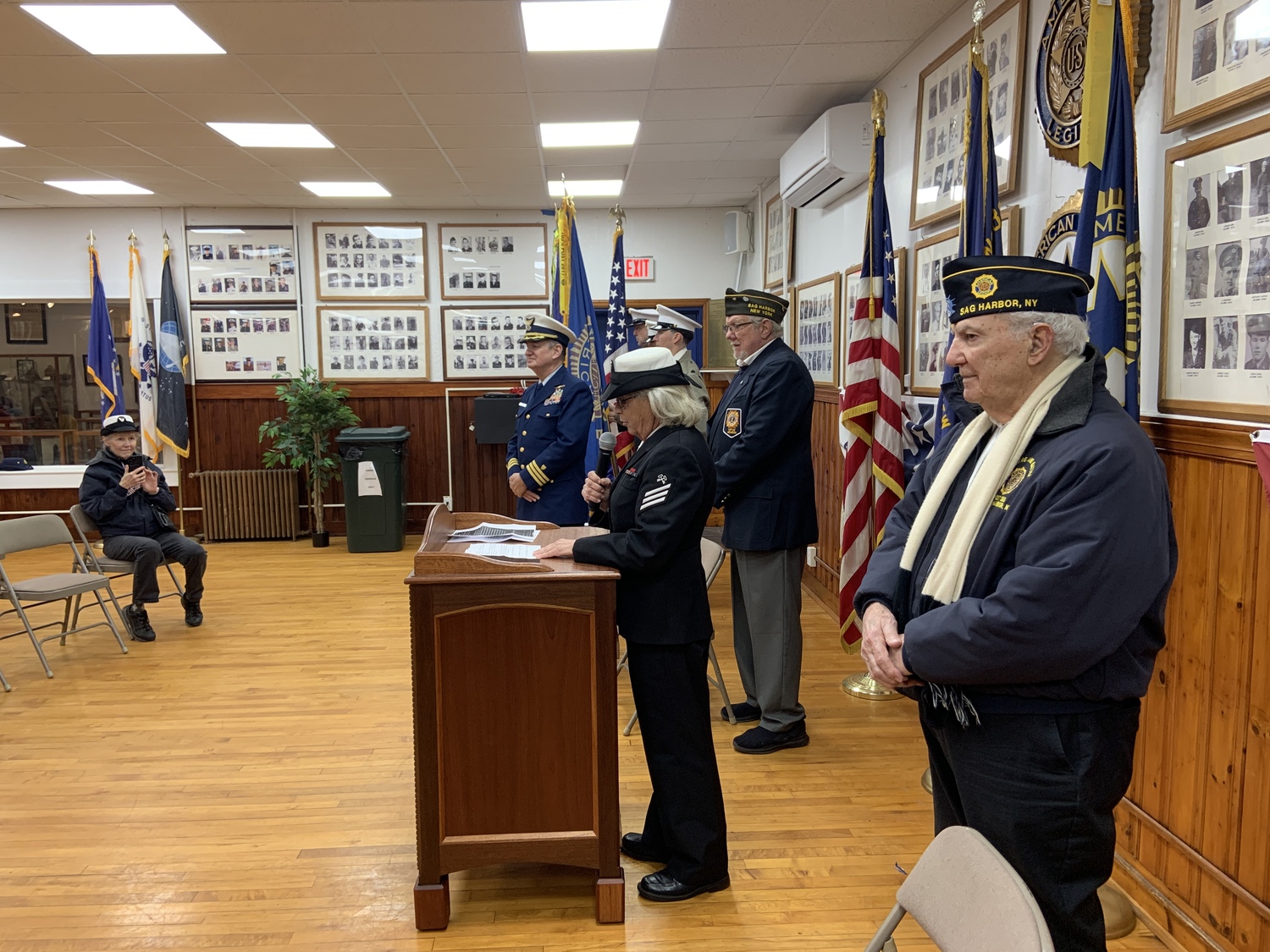 Theresa Labrozzi, a Navy veteran, spoke at Tuesday's Veterans Day service at the American Legion in Sag Harbor. Looking on, from left, were Veterans of Foreign War chaplain Paul Gerecke, VFW Senior Vice Commander Greg Keramis and American Legion Commander Jack Prizzi. STEPHEN J. KOTZ