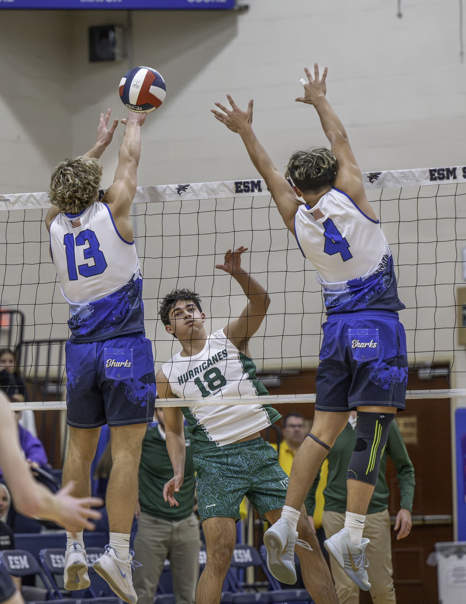 Senior outside hitter Jude Allen spikes the ball through Eastport-South Manor blockers in the second set. MARIANNE BARNETT