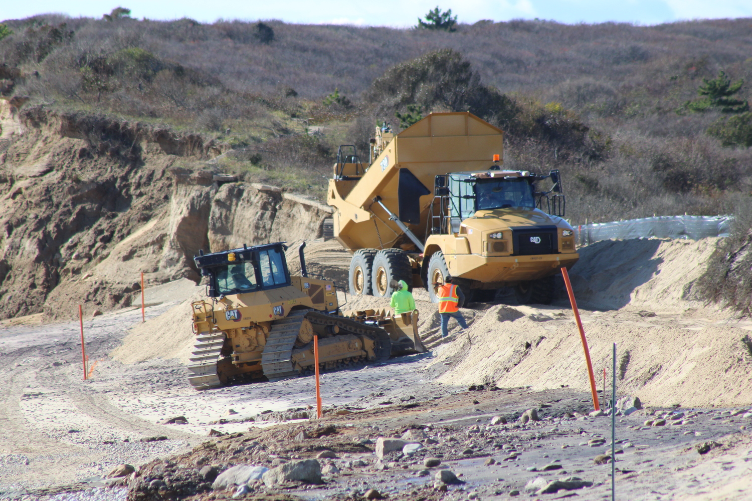 A truck lifts up its bed to deposit the sand that it had just transported from the parking lot. JACK MOTZ