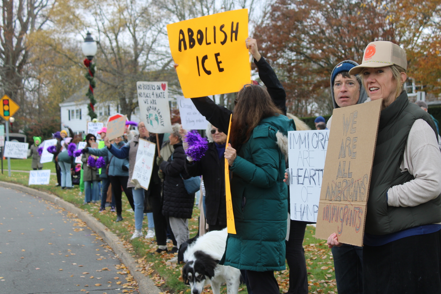 A protestor outside Hook Mill in East Hampton holds up a sign. JACK MOTZ
