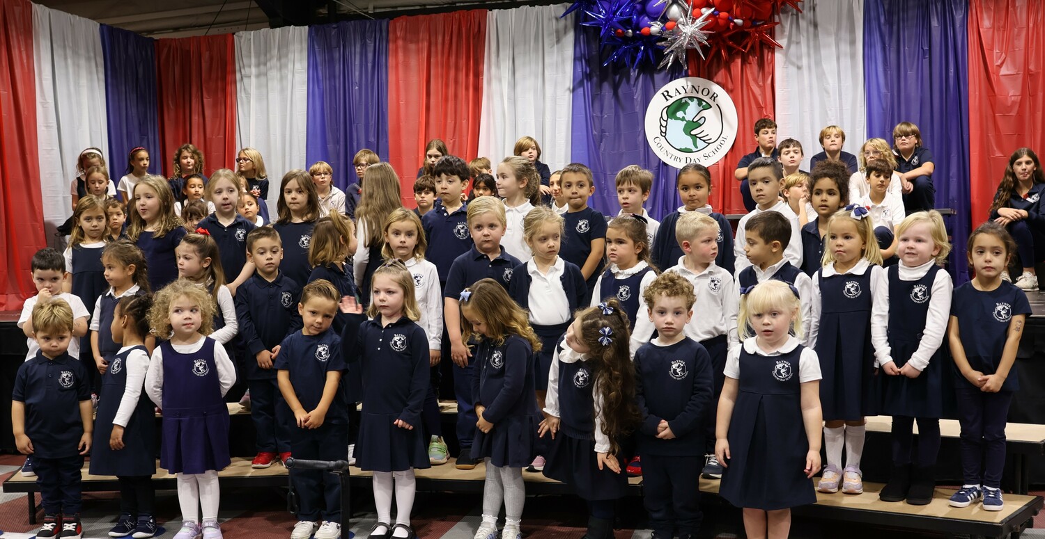 Raynor Country Day School hosted its annual Veterans Day ceremony last week with more than 60 veterans in attendance.  Under the direction of instrumental teacher Leanna Bartley, the Senior Band performed The Star Spangled Banner and This Is My Country.  Choral teacher, Suzanne Lewis, led the Pee Wee Chorus in a performance of America the Beautiful, as well as schoolwide choral performances of The Armed Forces Medley and We Give Thanks.  Student representatives demonstrated their appreciation by sharing reflective writing pieces to the veterans, which included second-grader Gigi Guerra, third-grader Roman Rogers, fifth-graders Lily Ramsammy, Sophia Maharlouei, and James Burkly, and sixth-grader Siena Babinsky.  In addition, sixth-grader Mo Buffa, performed Taps, while his classmates presented a wreath of honor during a moment of silence.
At the event, sixth-graders Porter Faulk and Levi Beaver presented a donation to Honor Flight Long Island from a recent student-led Jeans Day fundraiser. COURTESY RAYNOR COUNTRY DAY SCHOOL