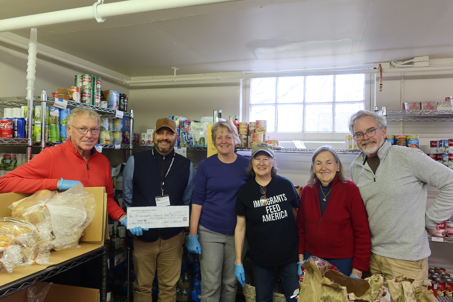 Each year, the South Fork Natural History Museum designates a portion of the proceeds from its Summer Gala to support food pantries serving underserved families on the East End, including the Bridgehampton Community Food Pantry. Bridgehampton Community Food Pantry Director Tom White. left, accepts the donation from SOFO Executive Director Frank Quevedo, second from left, while pantry volunteers look on. COURTESY SOUTH FORK NATURAL HISTORY MUSEUM