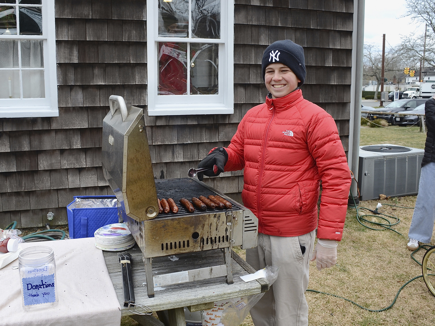 Timmy Mullen mans the grill at the East Hampton Historical Farm Museum Community Christmas Party on Saturday.  KYRIL BROMLEY
