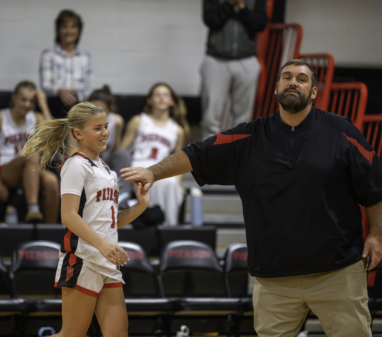 Pierson senior Ally Cottrell gets a high five from head coach John 