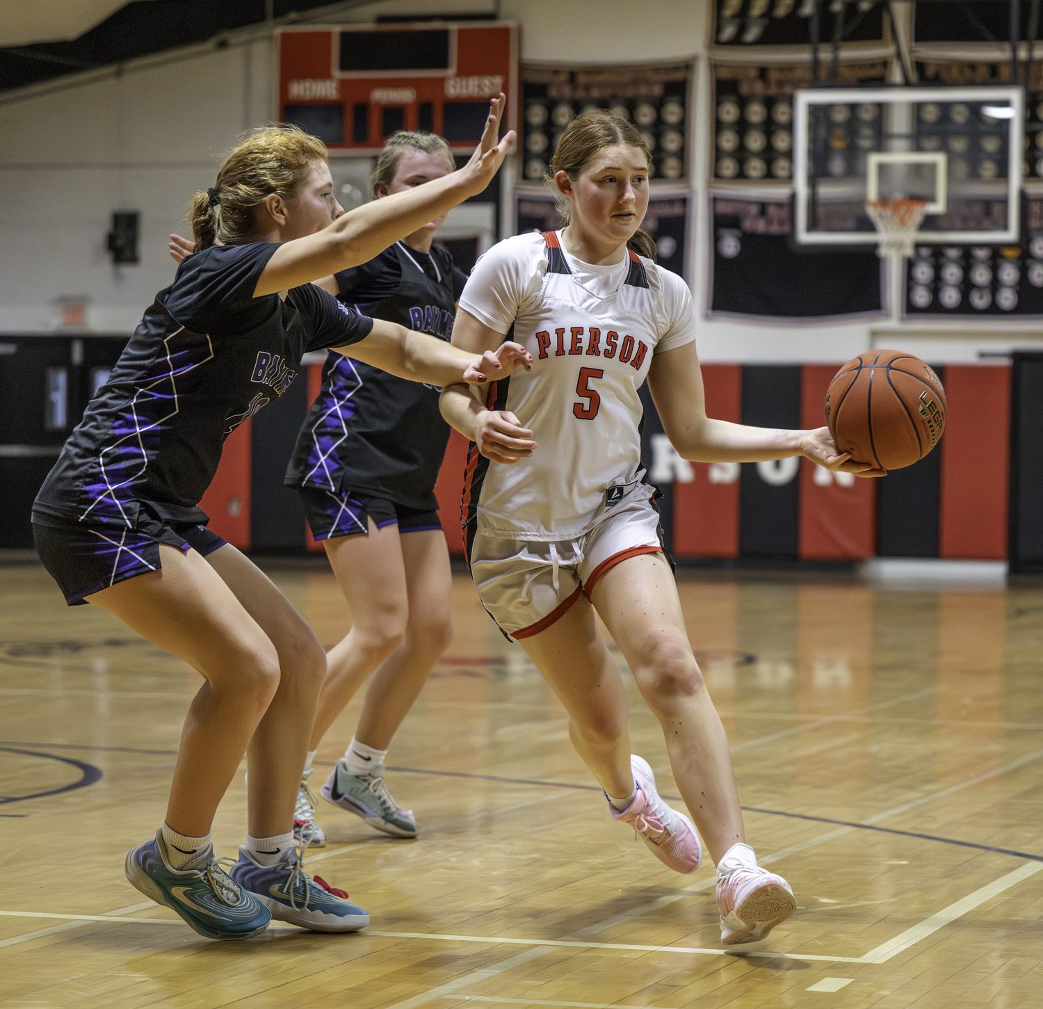 Pierson sophomore Josie Mott passes the ball off after drawing in a pair of Baymen defenders.  MARIANNE BARNETT
